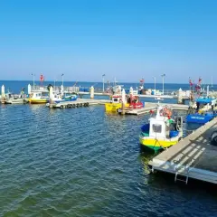 Port w Mechelinkach, gdzie cumują kolorowe łodzie rybackie. To idealne miejsce na spacer i podziwianie morskich atrakcji.