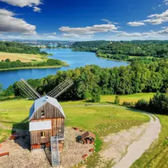 Wiatrak na tle jeziora i lasów. Tak właśnie wyglądają Kaszuby, malowniczy region Polski.
