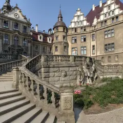 Kamienny zamek z wieżą i schodami. Warto zobaczyć, co to za moszna budowla!