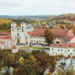Najstarszy klasztor w Polsce, benedyktyńskie opactwo na skale, otoczone jesiennymi drzewami.