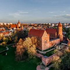 Zamek w Malborku, gdzie kiedyś rezydowali krzyżacy, w blasku zachodzącego słońca.