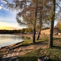 Zachód słońca nad jeziorem, plaża i drzewa. Skorzęcin atrakcje turystyczne czekają na odkrycie.