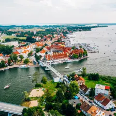 Malownicze miasta na Mazurach z widokiem na jezioro i liczne łodzie.