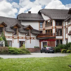 Elegancki hotel premium Wisła z drewnianymi elementami architektonicznymi i zadbanym ogrodem.