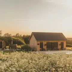 Drewniany domek z bali, beczka z gorącą wodą i basen na tle zachodzącego słońca. Idealne miejsce na **długi weekend**.