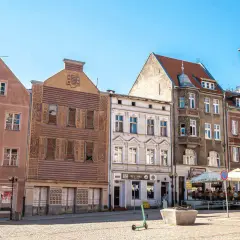 Kamienice na rynku w Olsztynie, głównym mieście Warmii. Słoneczny dzień, brukowany plac.