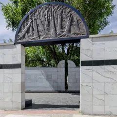 Umschlagplatz: monumentalny pomnik z kamienia z płaskorzeźbą i napisem. Miejsce pamięci o tragicznej historii.