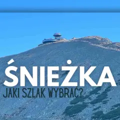 Szlak na Śnieżkę. Widok na górę z budynkami na szczycie i turystami idącymi ścieżką.