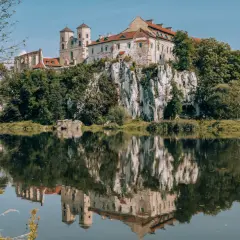 Zamek w Tyńcu na skale, odbijający się w spokojnej wodzie.