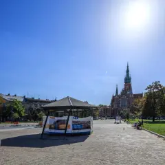 Słoneczny dzień na rynku podgórskim. W tle kościół św. Józefa, z przodu pawilon wystawowy.