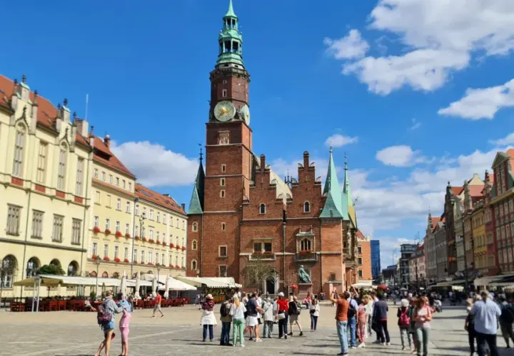 Tętniący życiem Rynek we Wrocławiu, z Ratuszem w centrum. Ludzie spacerują, podziwiając piękną starówkę wrocław.