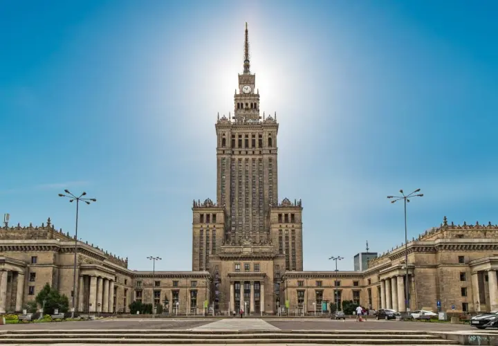 Imponujący Pałac Kultury i Nauki w Warszawie, jego monumentalna wysokość dominuje nad placem.