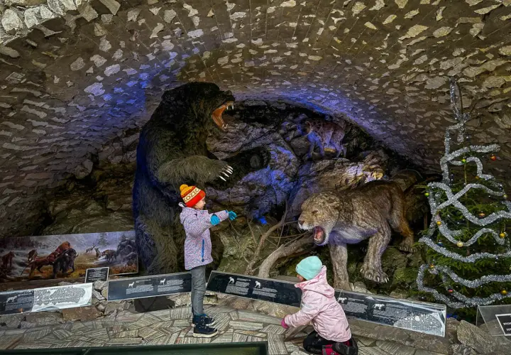 Dzieci zwiedzają jaskinię niedźwiedzia, podziwiając prehistoryczne zwierzęta. Bilety do tego miejsca są warte każdej ceny!