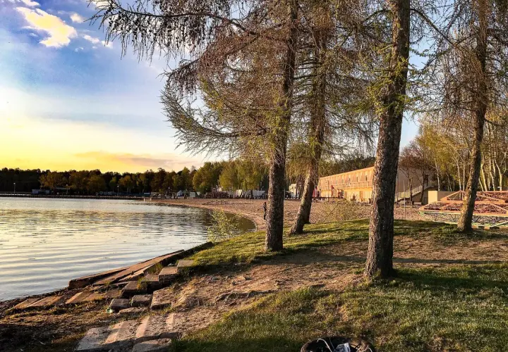 Zachód słońca nad jeziorem, plaża i drzewa. Skorzęcin atrakcje turystyczne czekają na odkrycie.