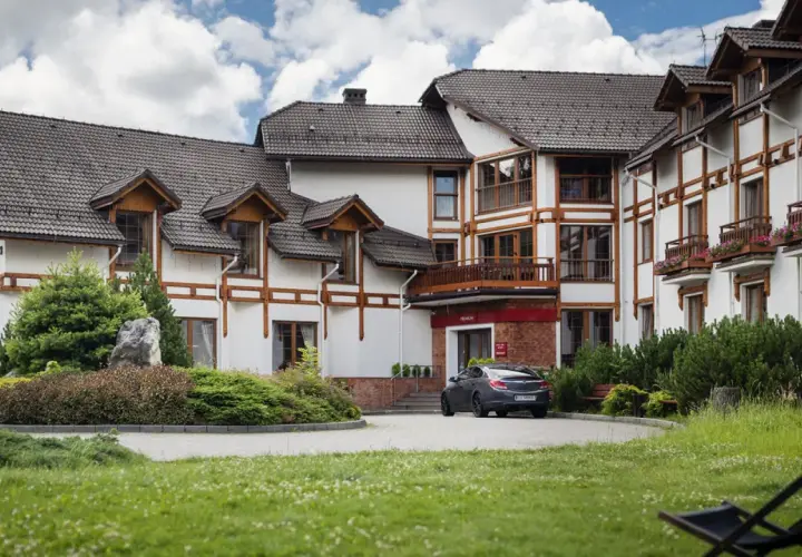 Elegancki hotel premium Wisła z drewnianymi elementami architektonicznymi i zadbanym ogrodem.