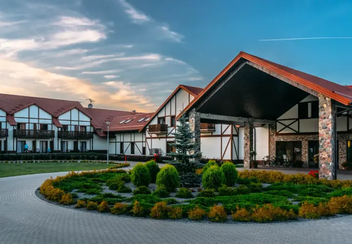 Hotel Mikołajki Leisure & Spa: piękne budynki z czerwonymi dachami, zadbany ogród i podjazd. Wiele pozytywnych hotel mikołajki leisure & spa opinie.