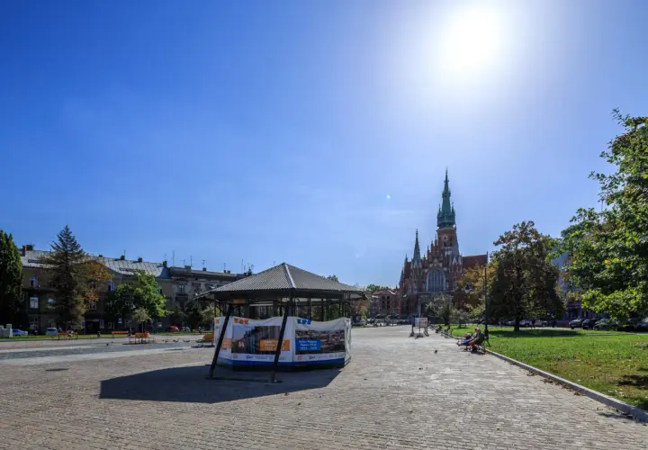 Słoneczny dzień na rynku podgórskim. W tle kościół św. Józefa, z przodu pawilon wystawowy.