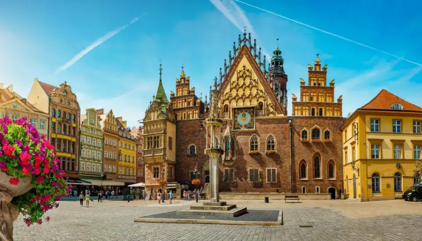 Rynek we Wrocławiu, idealne miejsce na city break z Wrocławia. Kolorowe kamienice, zabytkowy ratusz i kwitnące kwiaty tworzą malowniczy widok.