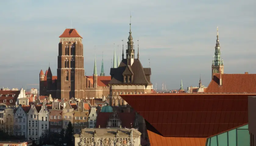 Widok na zabytkowe kamienice i wieże Starego Miasta Gdańsk.