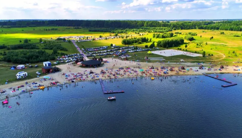 Tętniące życiem jeziora na Dolnym Śląsku latem. Plaża pełna ludzi, kempingi, parkingi i mnóstwo zieleni.