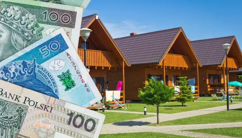 Zniżki na booking! Polskie banknoty przed domkami letniskowymi.