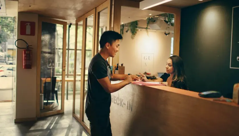 Mężczyzna i kobieta przy hotelowej recepcji.