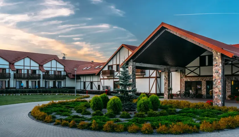 Hotel Mikołajki Leisure & Spa: piękne budynki z czerwonymi dachami, zadbany ogród i podjazd. Wiele pozytywnych hotel mikołajki leisure & spa opinie.