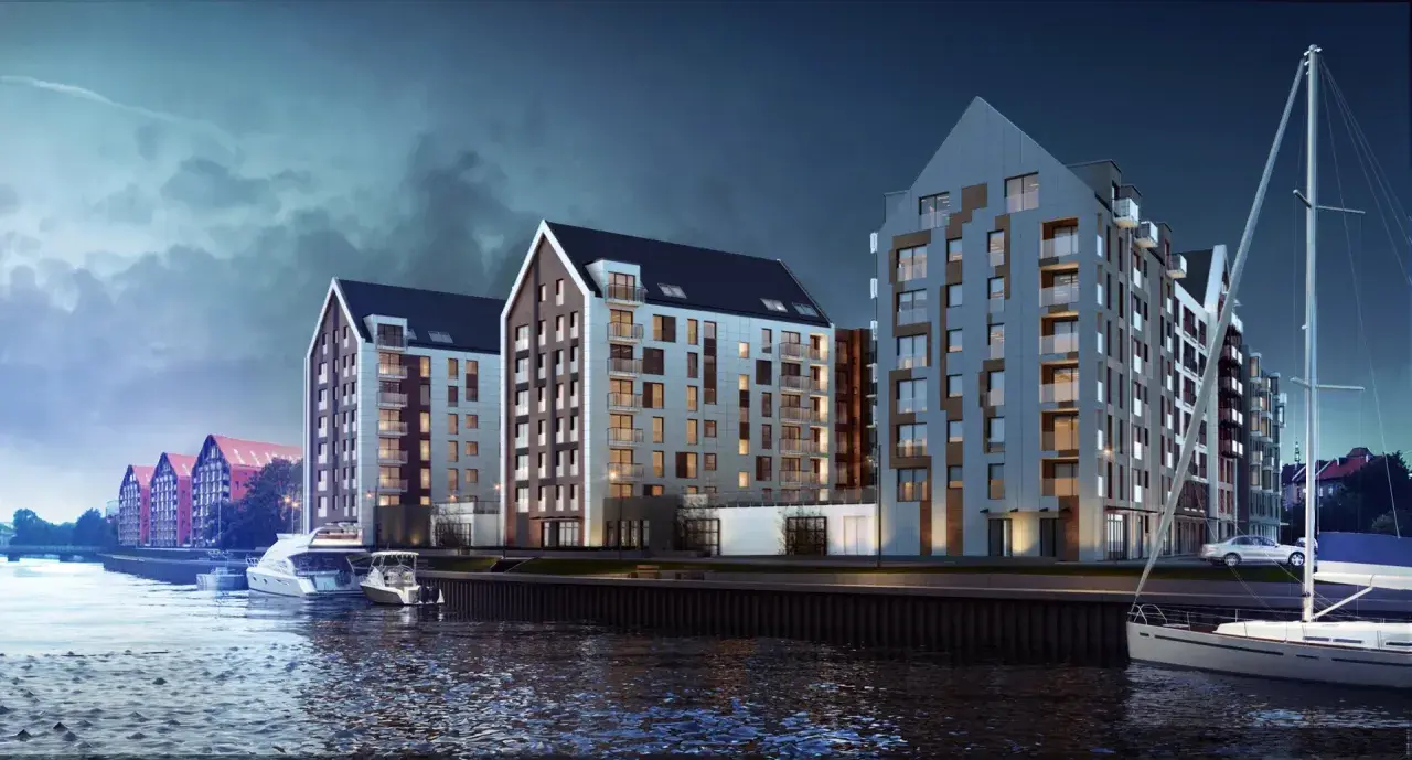 Nowoczesne apartamentowce nad wodą w Gdańsku, przy ulicy Chmielnej. Widok z rzeki na budynki i zacumowane jachty.