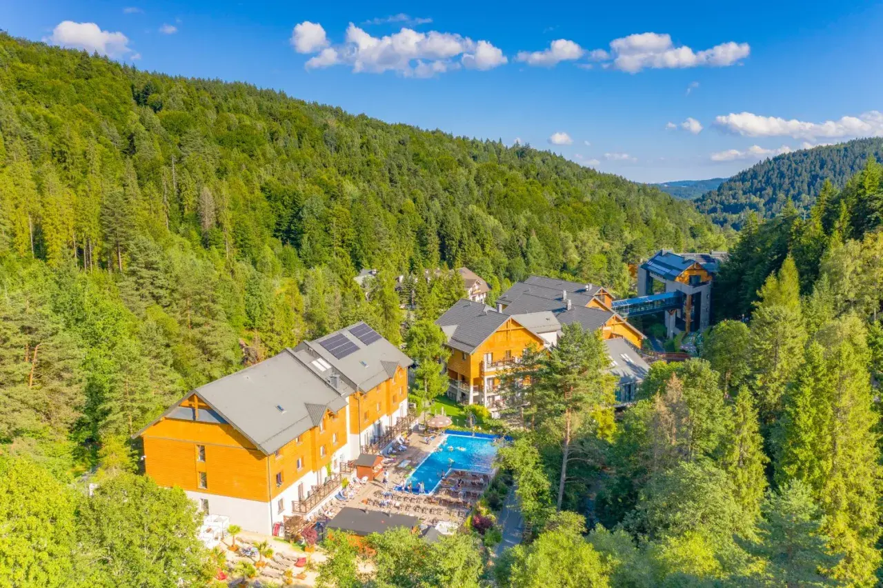 Idealne miejsce, gdzie na majówkę w Polsce: hotel w otoczeniu zielonych lasów, z basenem i miejscami do wypoczynku.