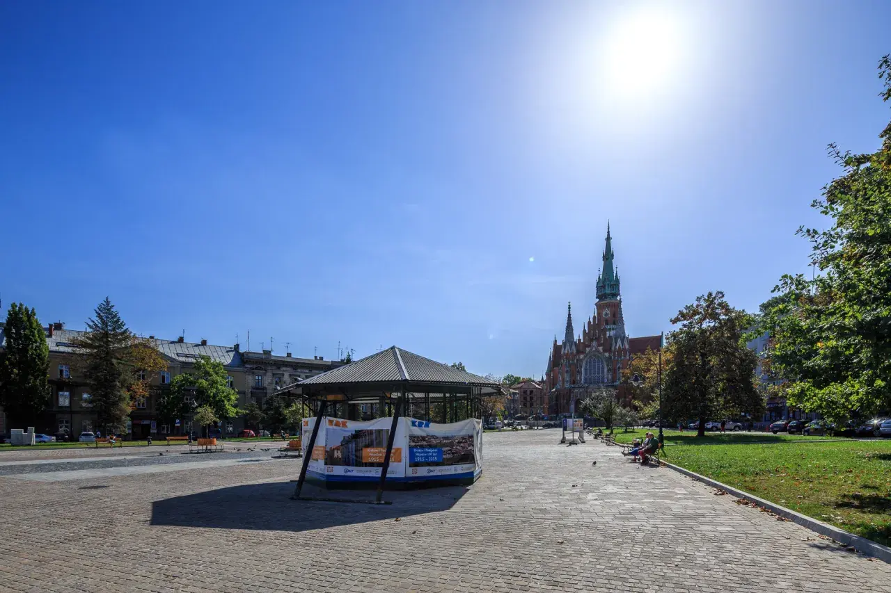 Słoneczny dzień na rynku podgórskim. W tle kościół św. Józefa, z przodu pawilon wystawowy.