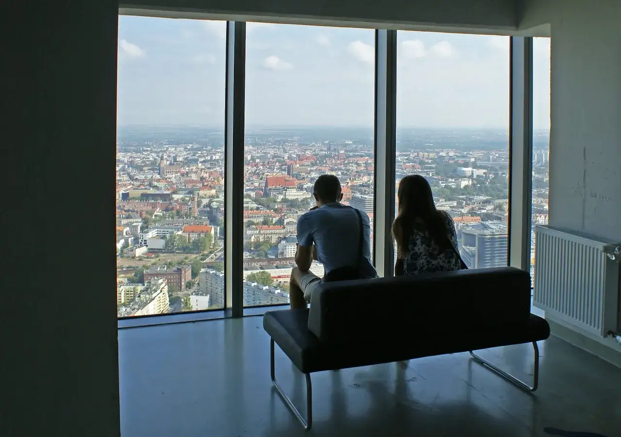 Para ogląda widok na miasto z najwyższego budynku we Wrocławiu.