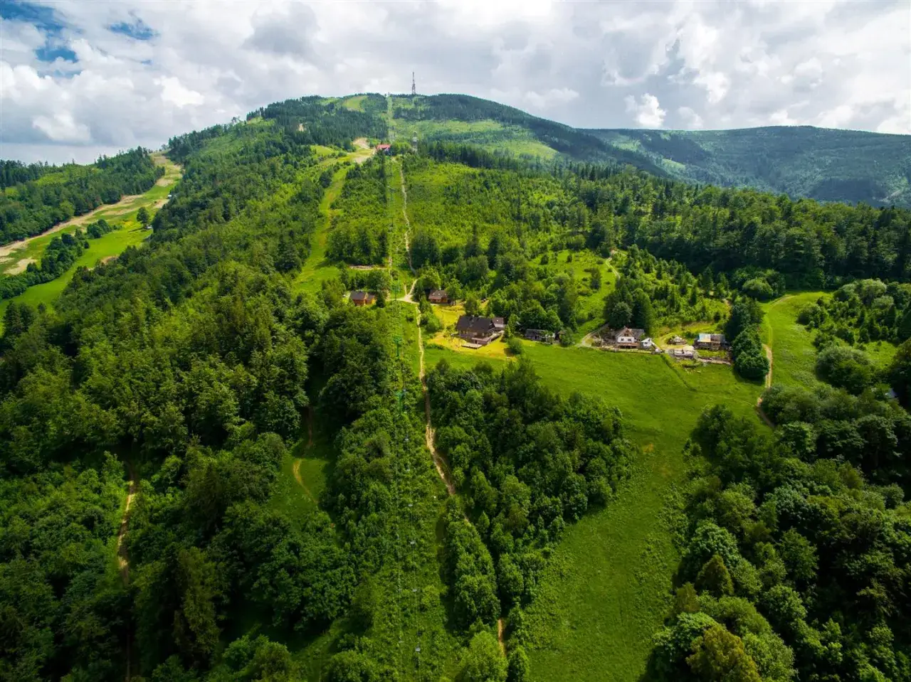 Zielony szlak na Skrzyczne wije się wśród lasów i polan, prowadząc do górnej stacji wyciągu.
