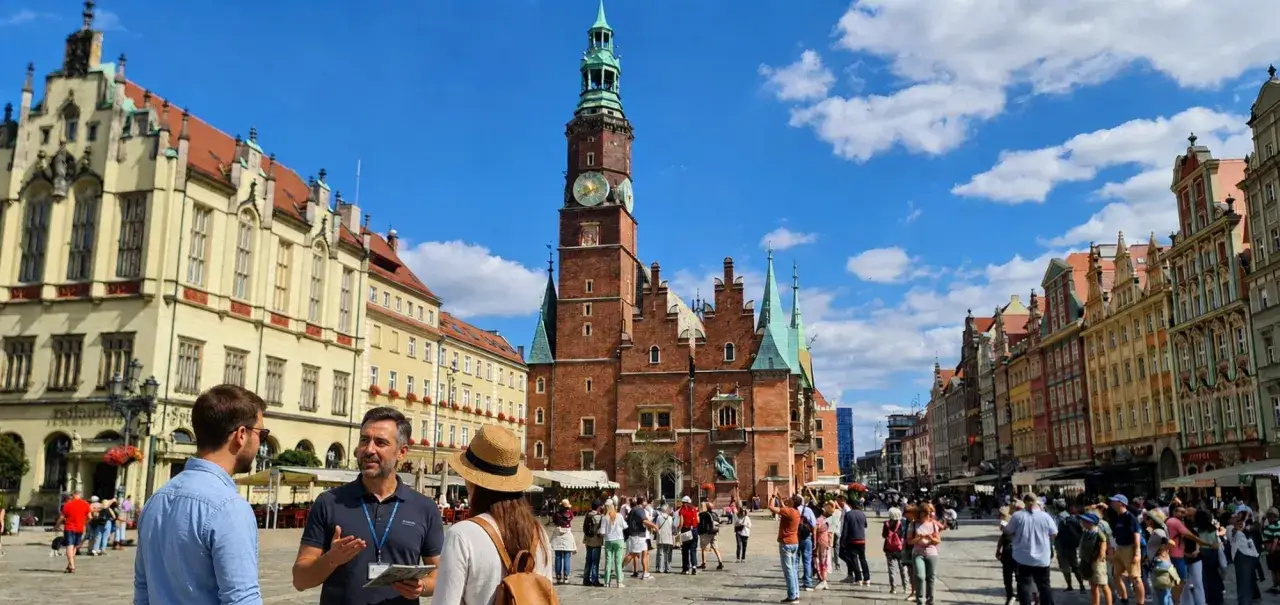 Spacer po wrocławskim Rynku. W tle Ratusz i kolorowe kamienice.