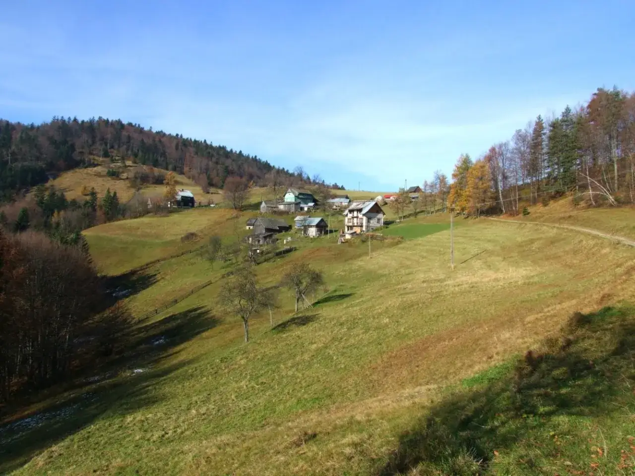 Krajobraz górski w Krynicy-Zdroju, z domkami na zboczu i jesiennymi drzewami.