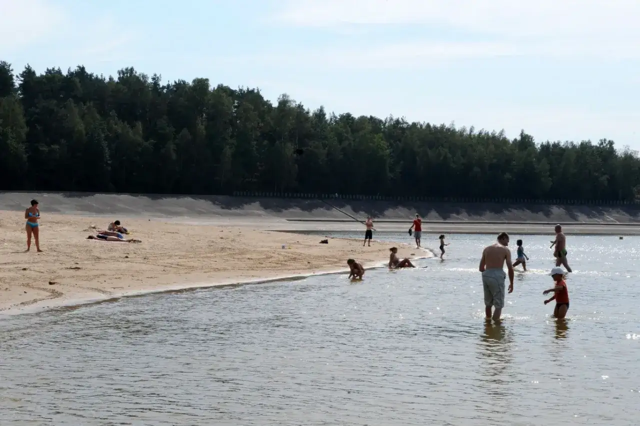 Ludzie kąpią się i opalają na piaszczystej plaży nad jeziorem Chańcza.