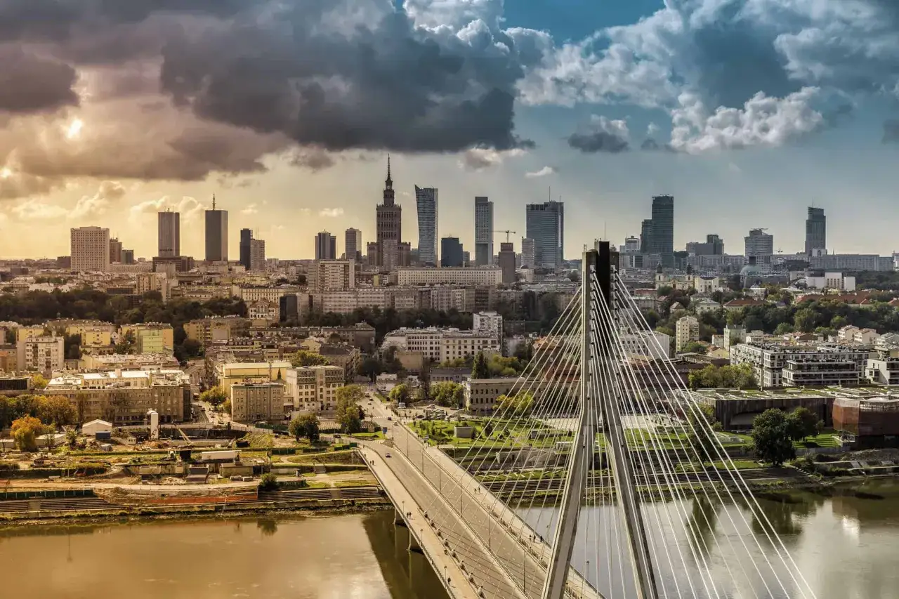 Widok na nowoczesną architekturę i most w Warszawie, stolicy Polski, o zachodzie słońca.
