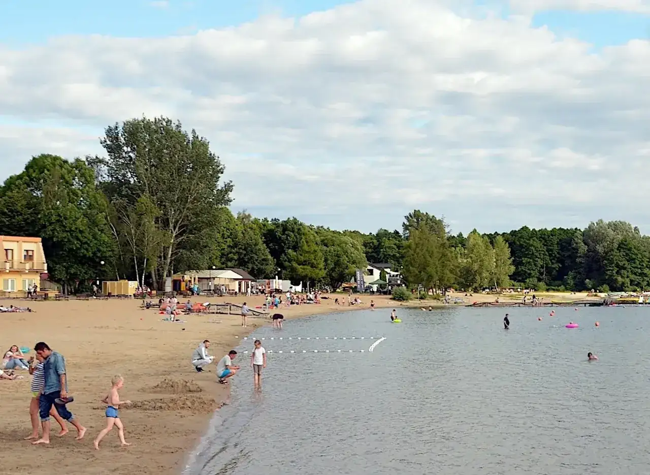 Plaża w Skorzęcinie tętni życiem. Ludzie odpoczywają na piasku, kąpią się w jeziorze i spacerują. To idealne miejsce na letnie atrakcje.